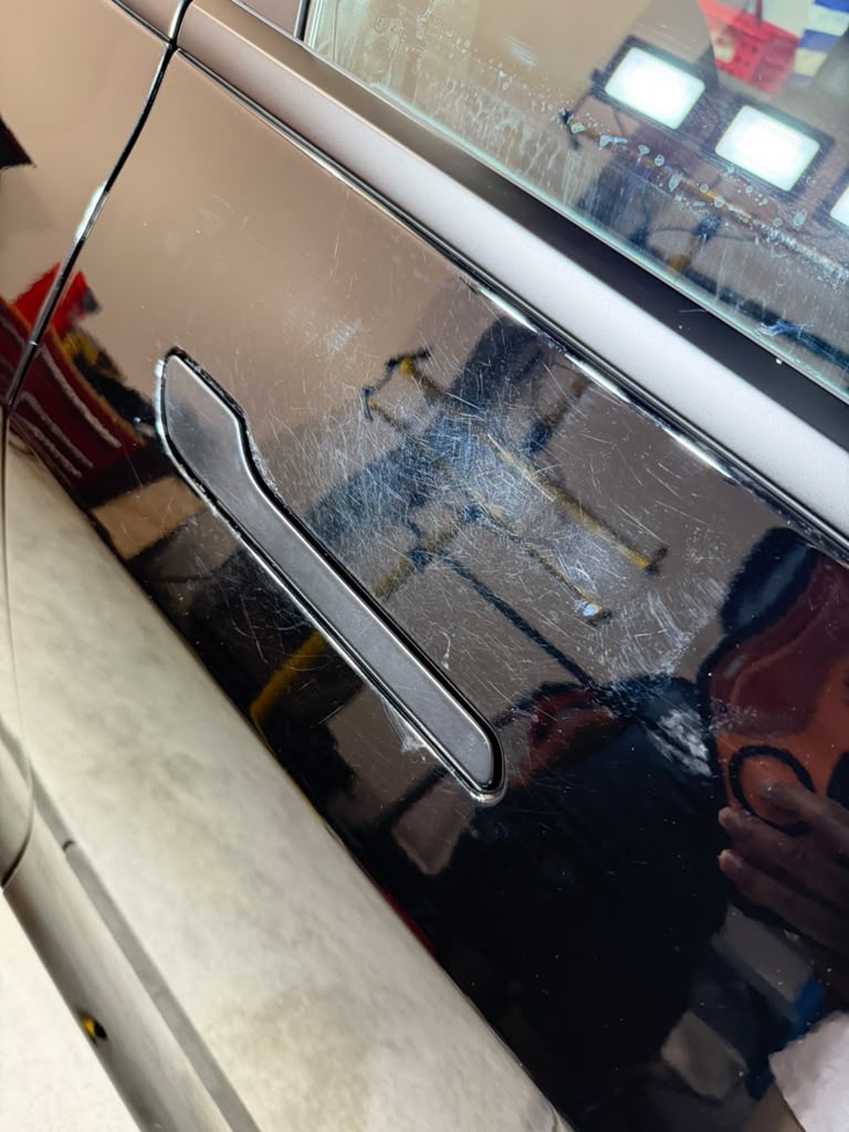 Tesla before detailing with heavy swirl marks and dull finish